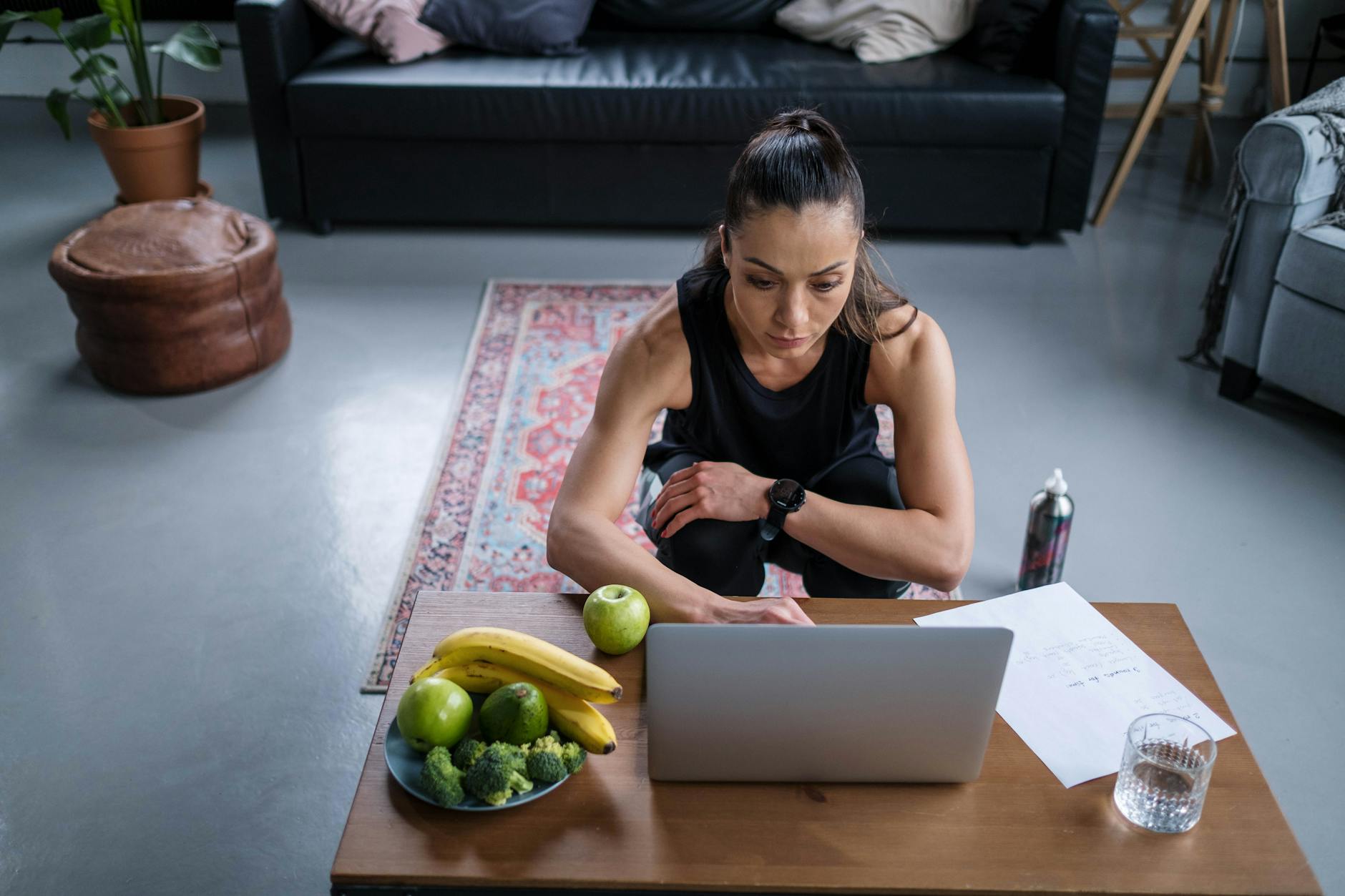 a woman using her laptop on a wooden table